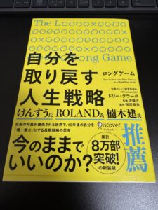 机の上に置いた書籍『ロングゲーム 自分を取り戻す人生戦略』の表紙