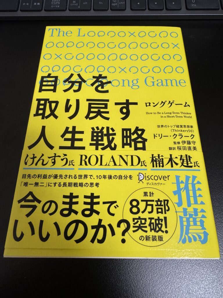 机の上に置いた書籍『ロングゲーム 自分を取り戻す人生戦略』の表紙